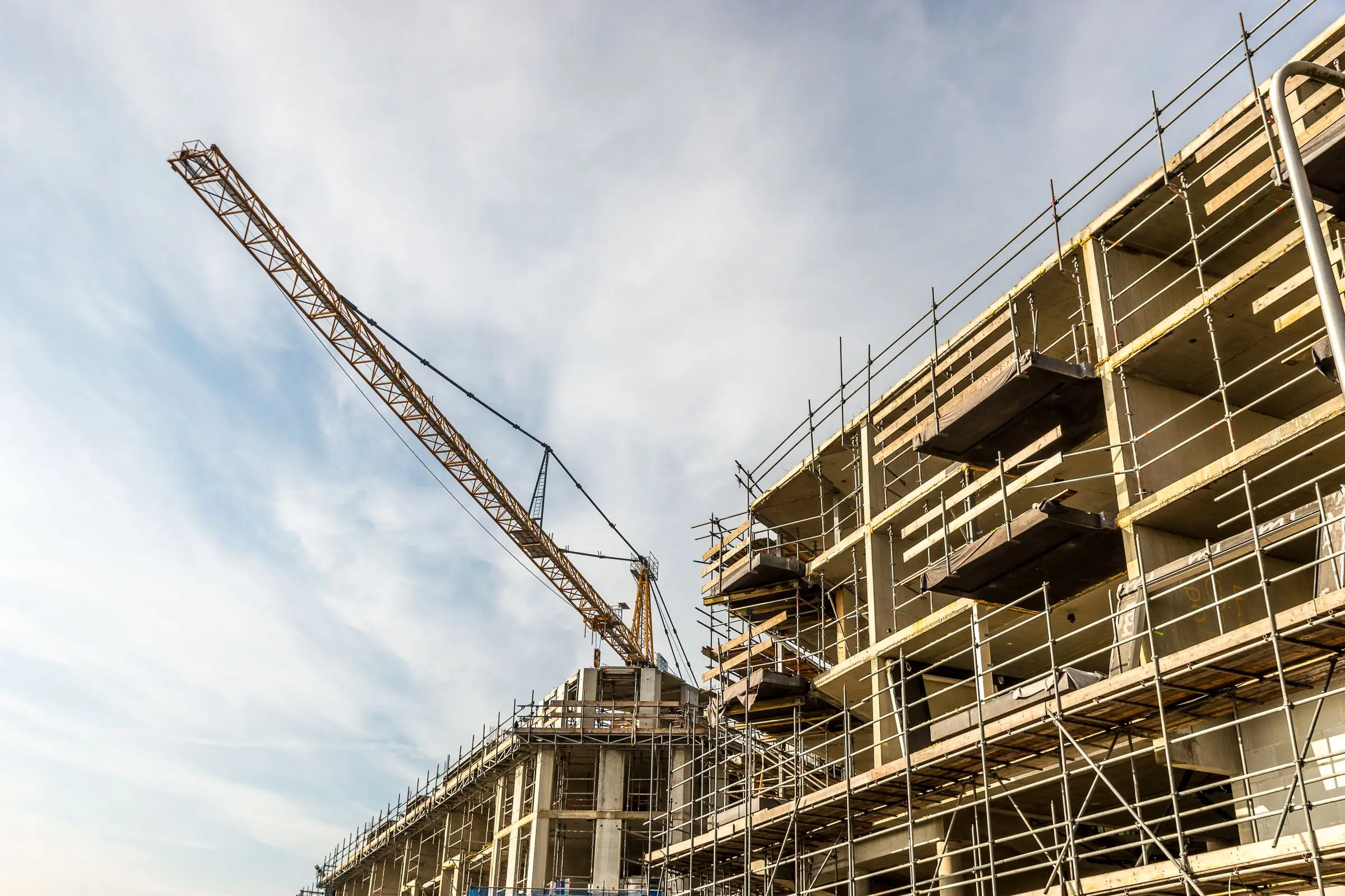 Palazzina residenziale in costruzione con ponteggi e gru
