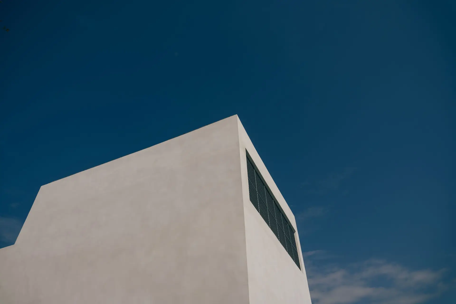 Edificio bianco dalle linee essenziali contro un cielo blu intenso